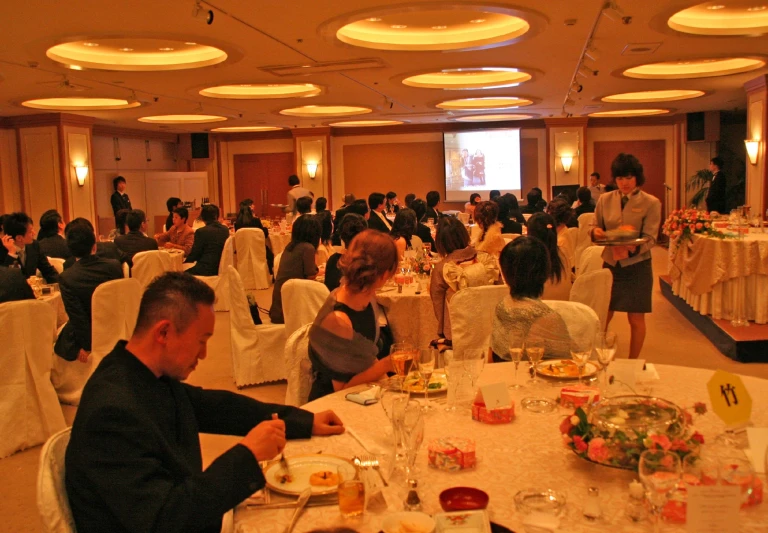 a banquet hall filled with tables covered in people