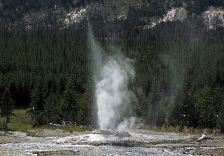 steam rises out of the ground as a hiker looks on