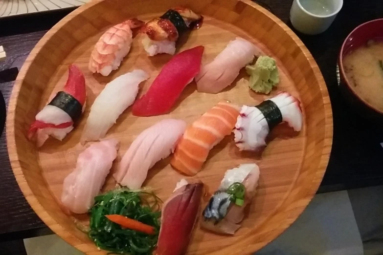 a dish is filled with sushi and vegetables