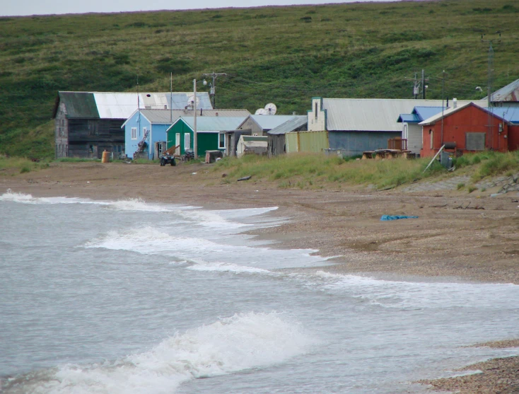 a group of buildings sit near the shore