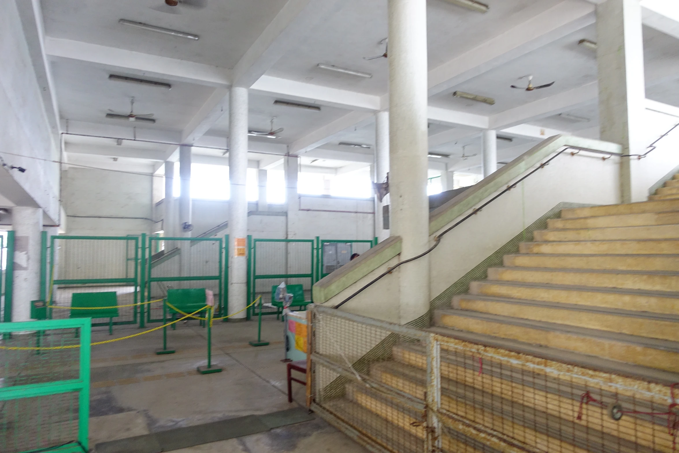 an empty stairway in a building with some green barricades