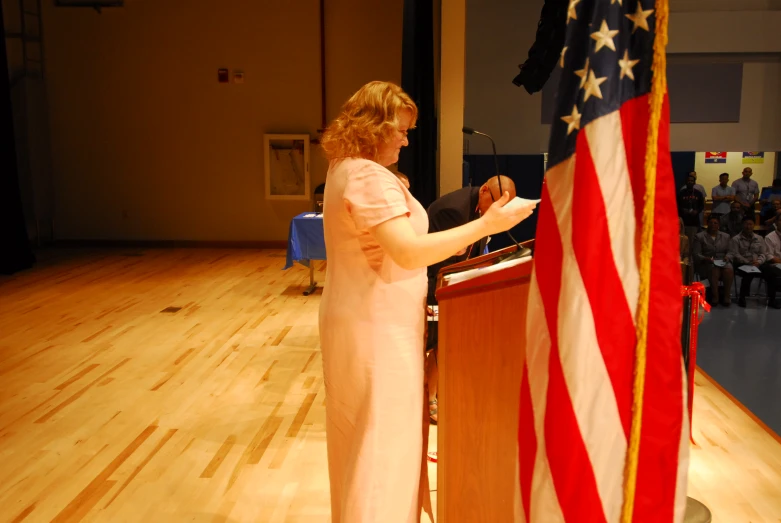 a woman standing in front of a podium with an american flag on it