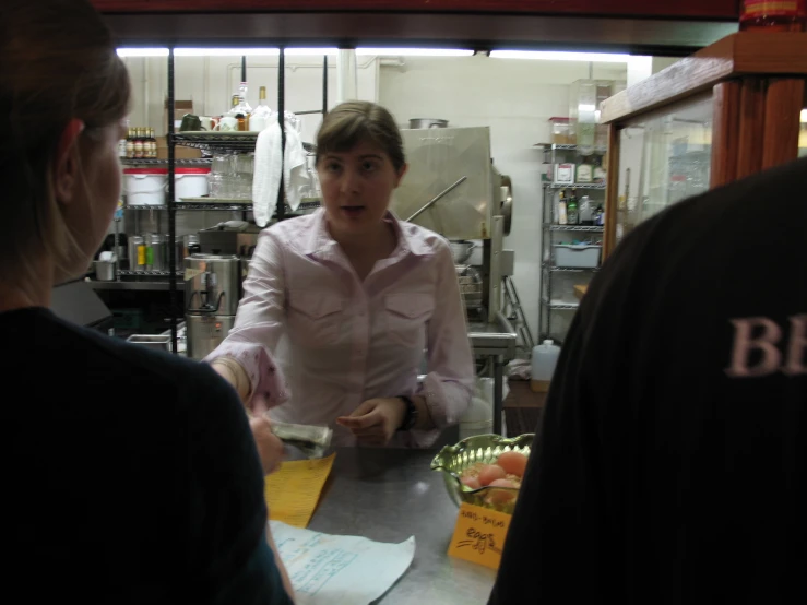 a woman standing behind a counter in a restaurant