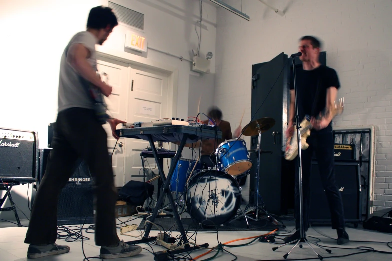 two men playing instruments in a white room