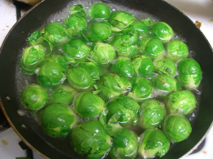 some green vegetables are cooking in a pan