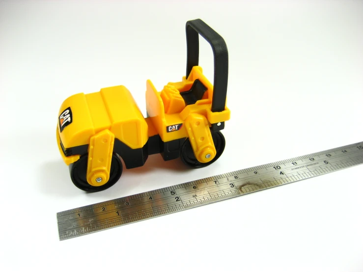 a toy car sitting next to a ruler