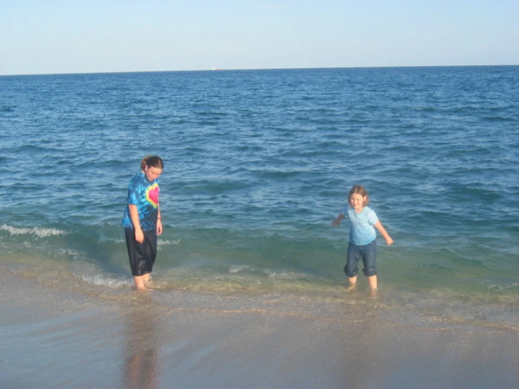 a boy and girl are standing in the ocean water