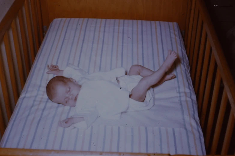 a baby is sleeping in a wooden crib