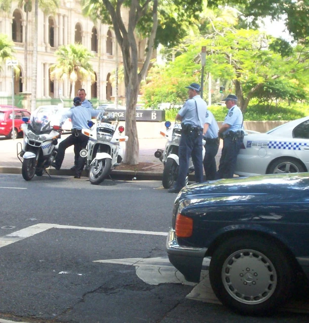 two men stand next to some parked motorcycles