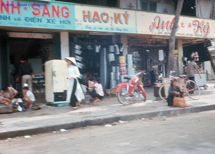 a motorcycle parked in front of a building with a few shopfronts