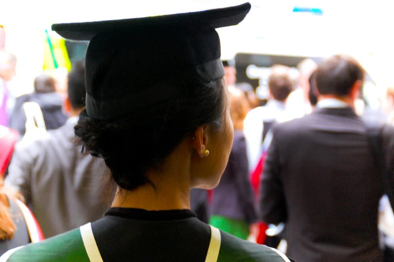 a woman wearing a gown and hat is facing forward