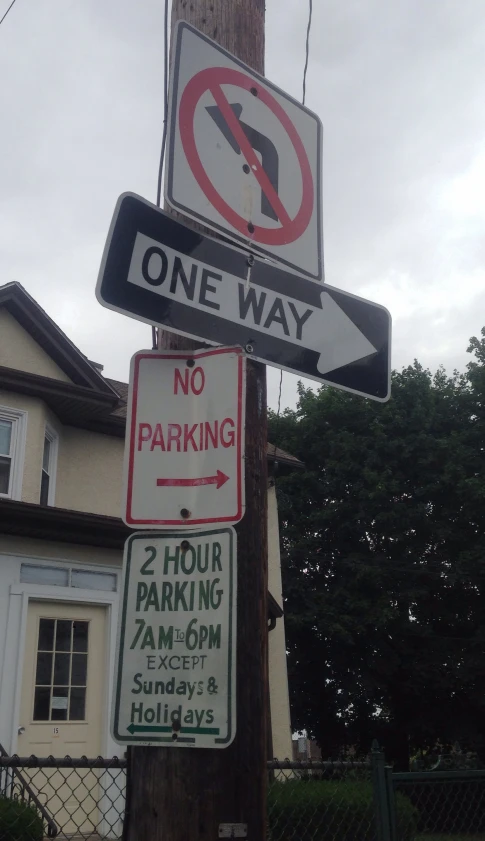 several traffic signs are attached to a telephone pole