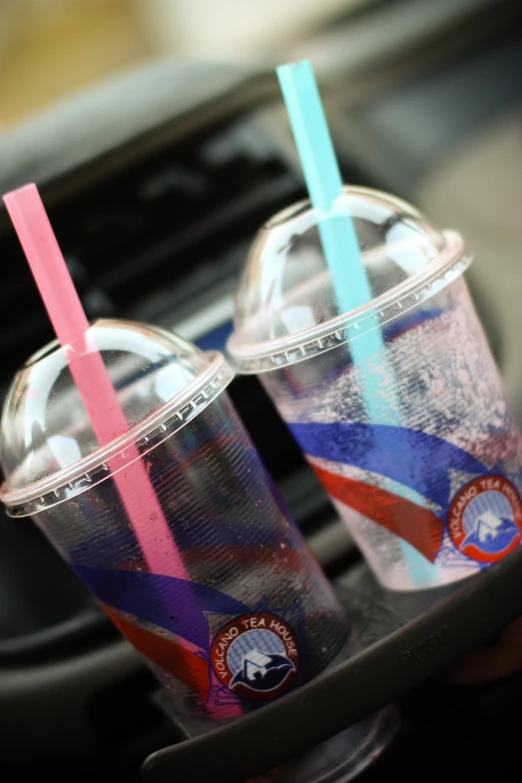 two pink and blue drinking glasses one with the same drink