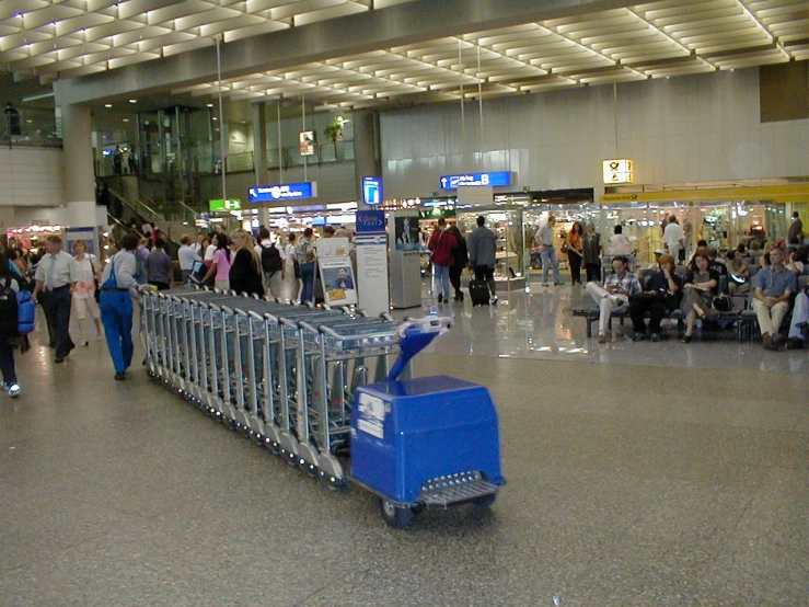 a luggage cart sits idle in a crowded terminal