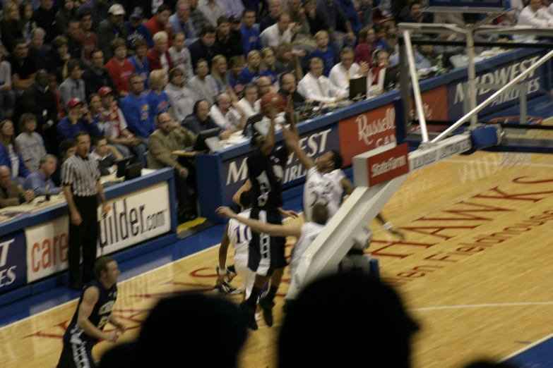 the basketball players are playing the game in a crowded arena