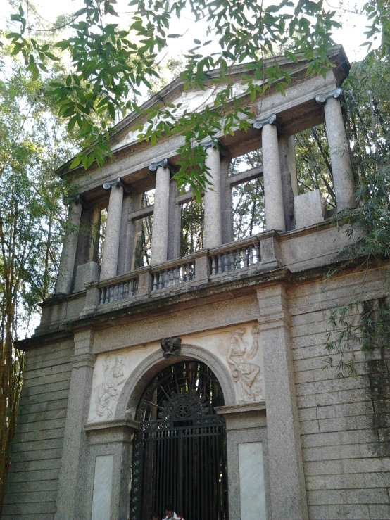 a gray and white old building has a door