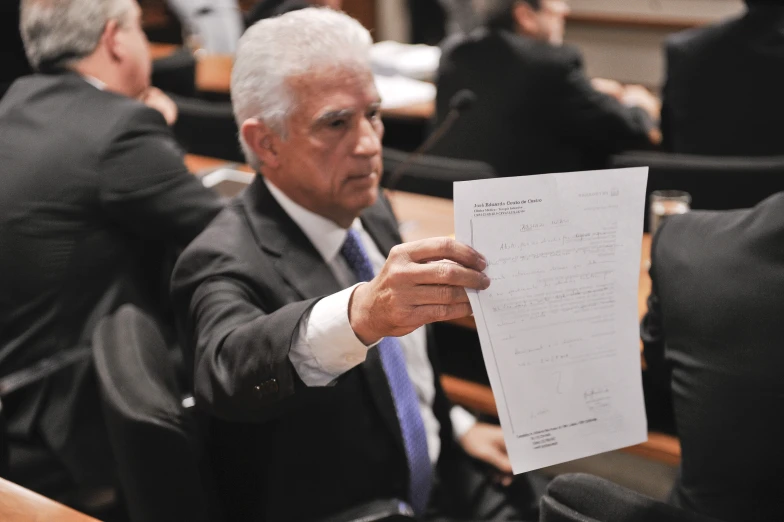 a man is looking at a piece of paper in his hand