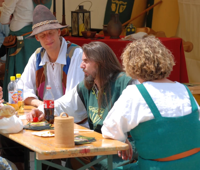 a group of men are eating food at the table