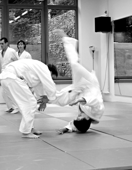 two young men doing karate tricks in an indoor gym