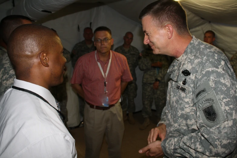 a military officer talks with another man in an area