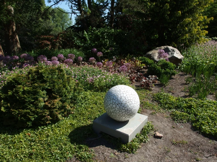 a large, white sphere statue sitting in the grass