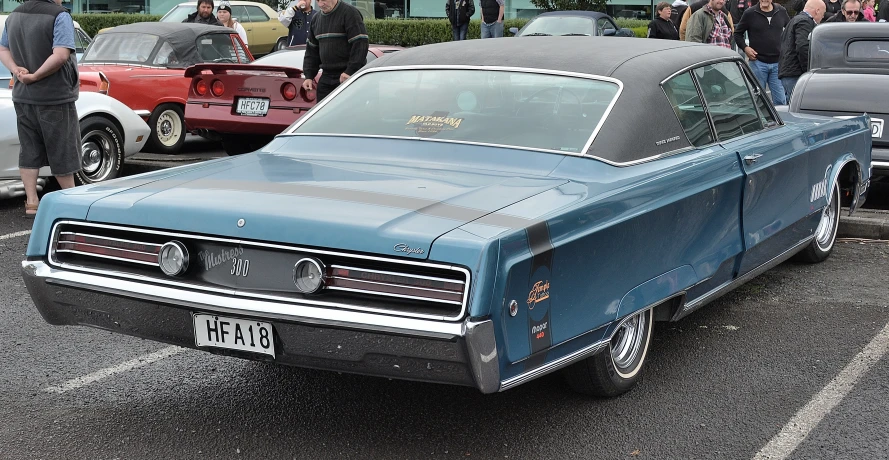 an older car in front of many parked cars