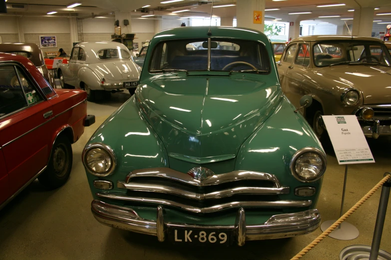 vintage cars are shown inside a garage with no one around