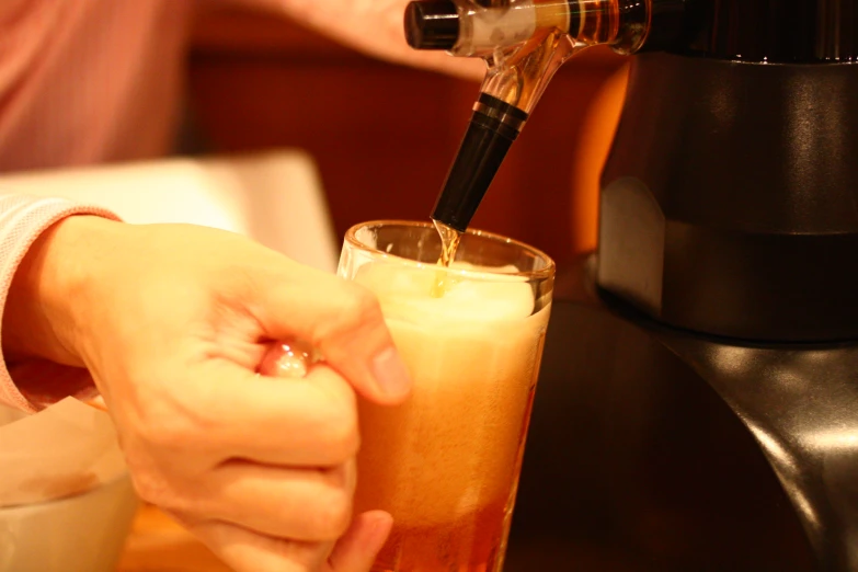 someone is pouring some drink into a glass