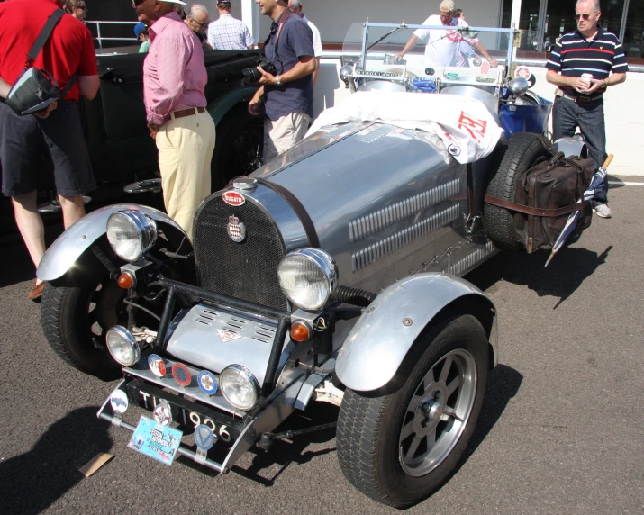 people gathered around a race car being displayed