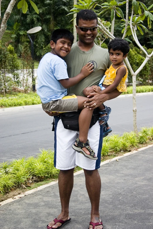 two children sit in the arms of a man