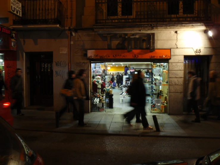 a group of people walk through an empty building on a busy street