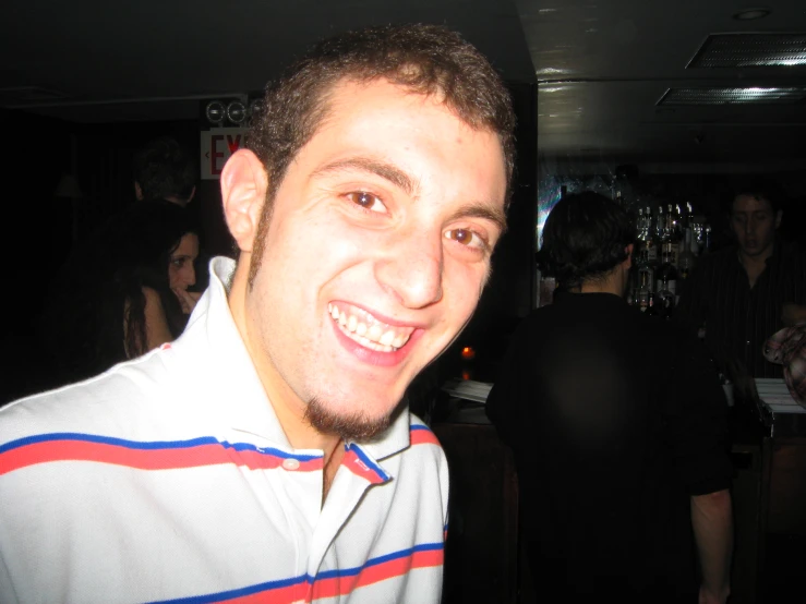 a man in a striped shirt smiling at the camera