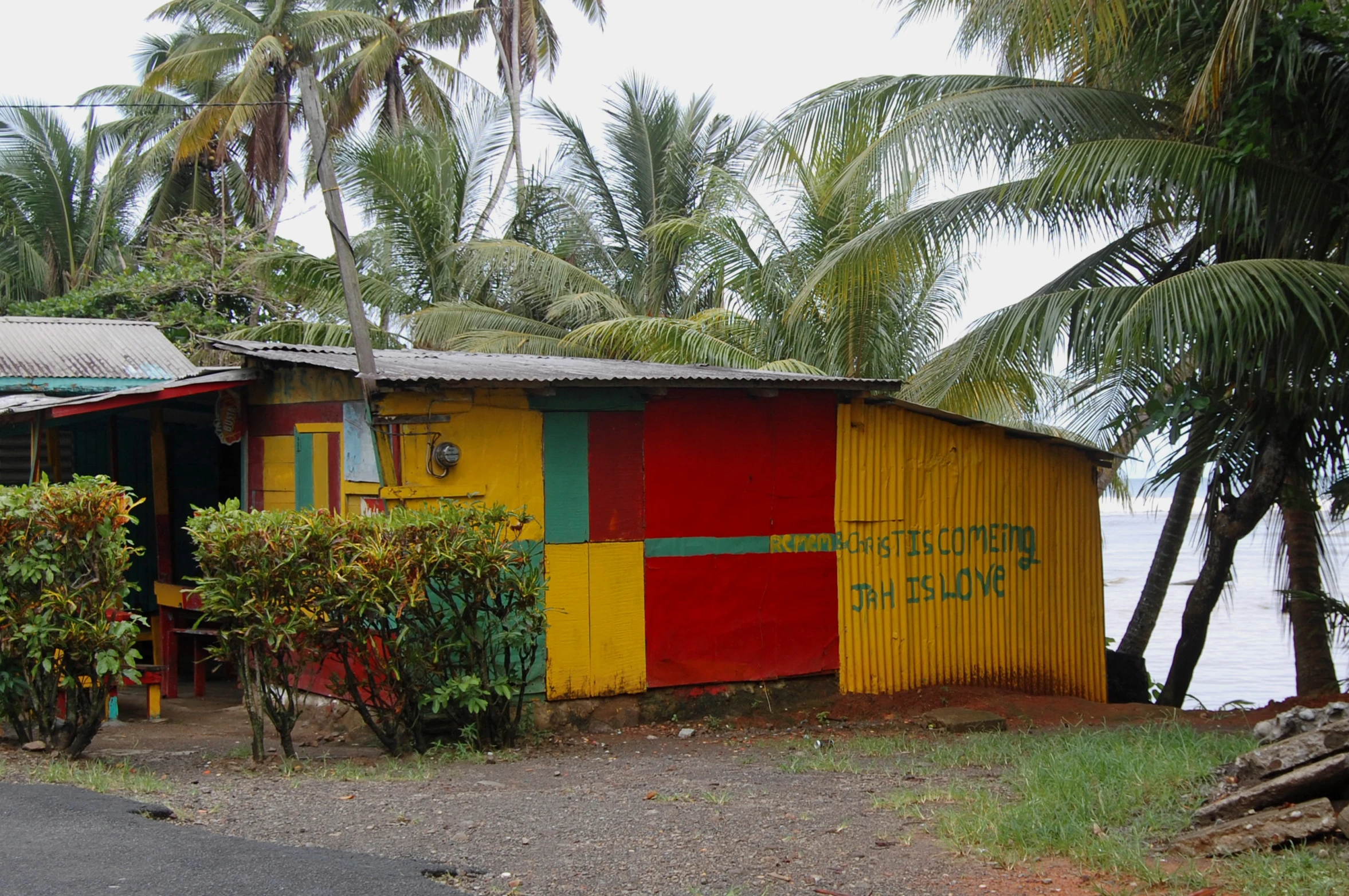 a house painted bright colors with a beach in the background