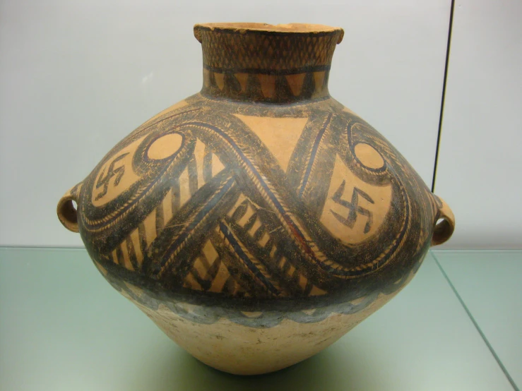 a old brown and black vase is on display