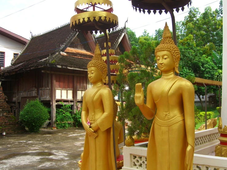 three statues sitting in front of a building