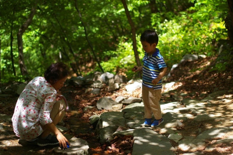 a woman and a child sitting on some rocks