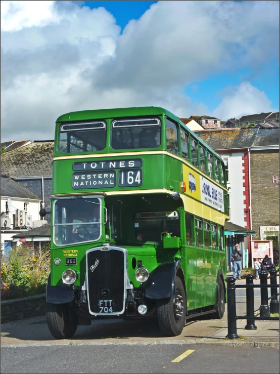 a double decker bus parked in a lot next to buildings