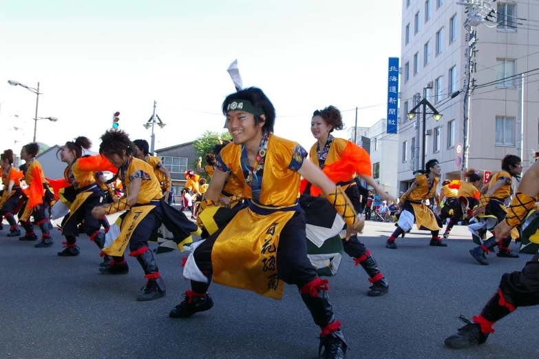 people in traditional japanese costumes dancing and carrying orange umbrellas