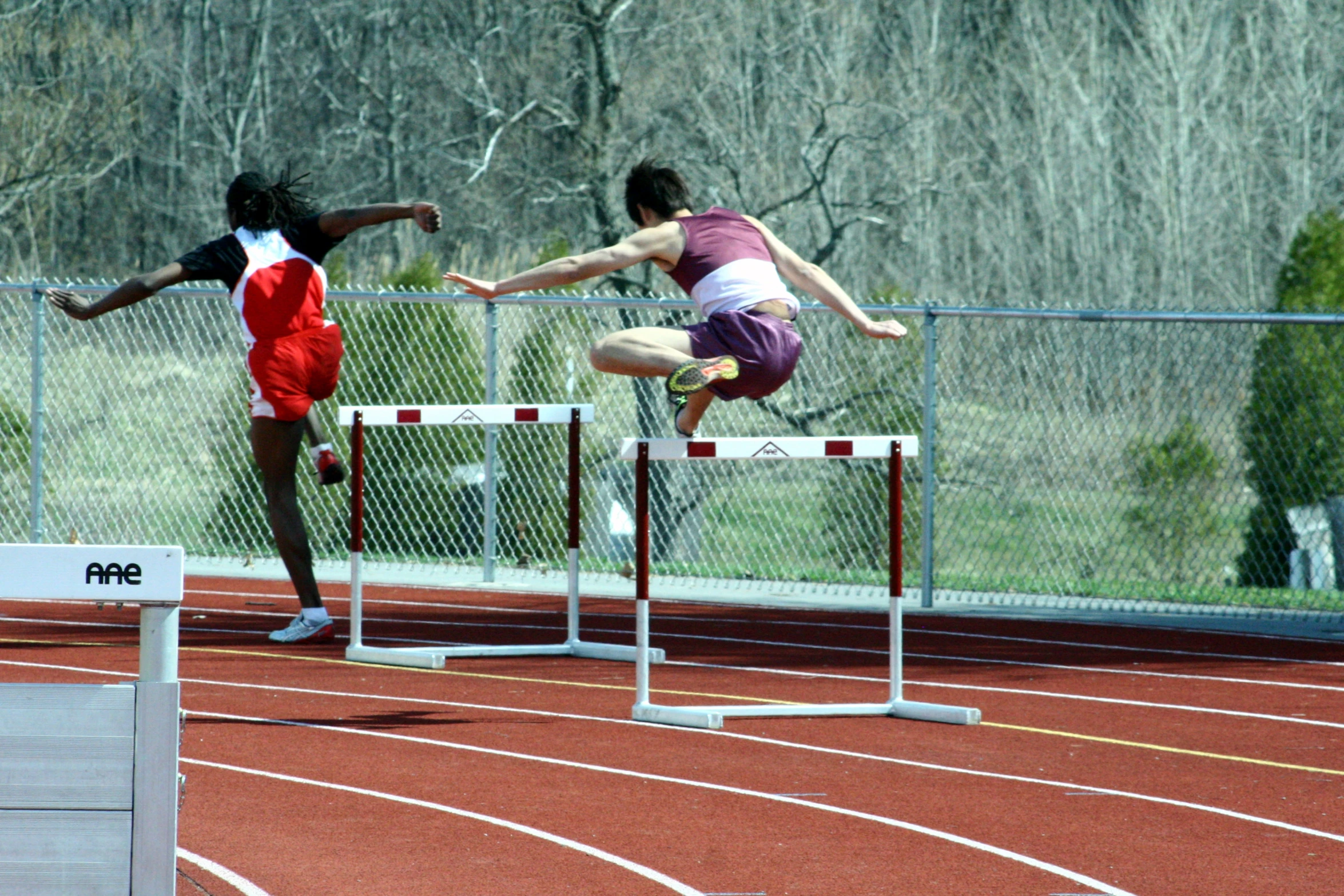 a man jumping over a hurdle on a running track