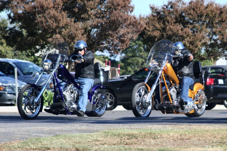 two men on motorcycles riding on the road