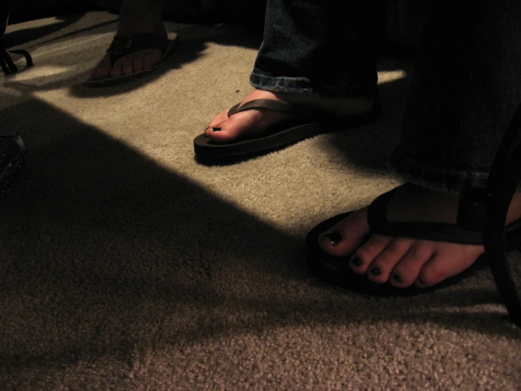 feet and feet are standing on a carpeted floor