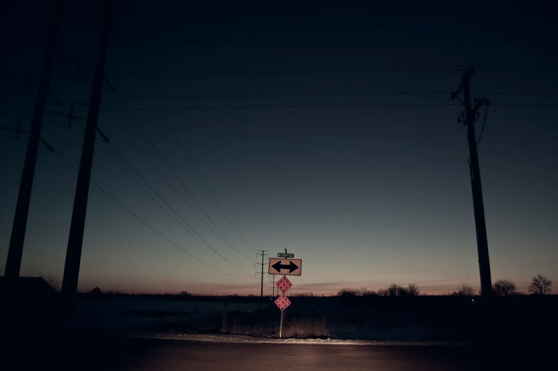 the intersection at dusk is quiet and empty