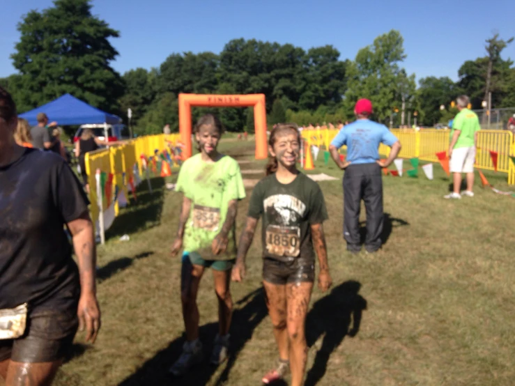 three women walking through a grassy field at a race