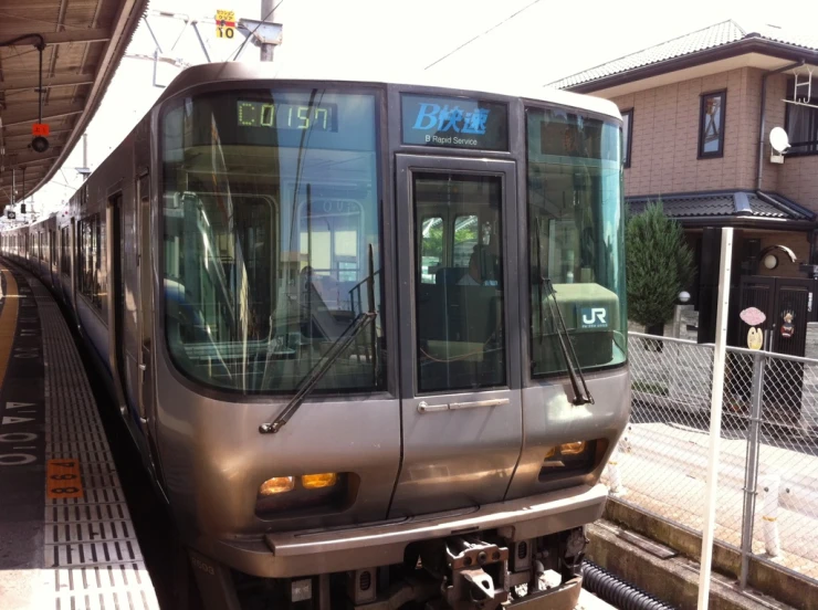 a train stopped at a platform in front of a building