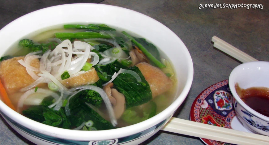 the soup is made up of vegetables, meats and noodle