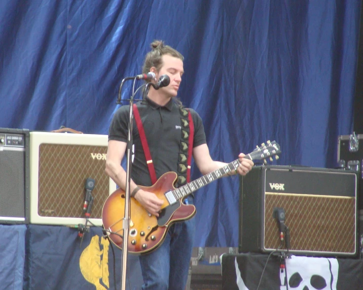 a man playing an electric guitar with a mic