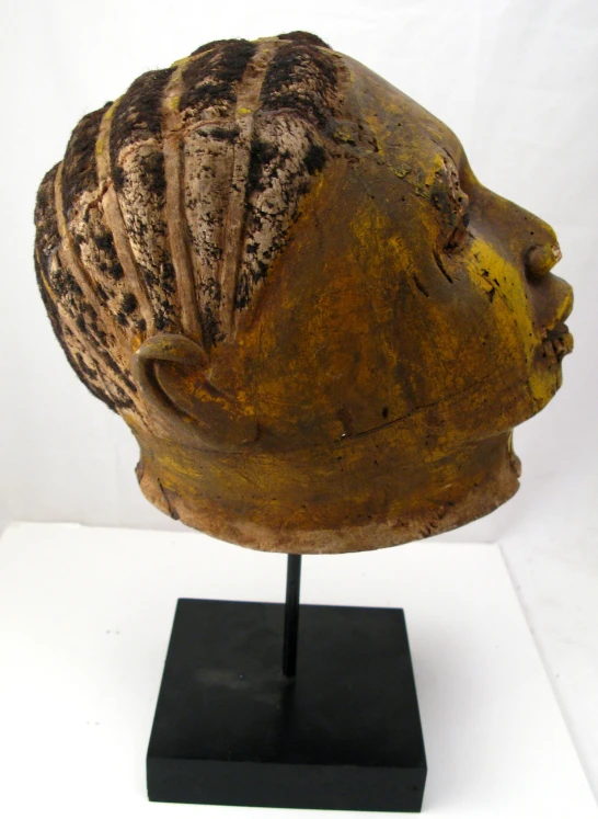 an african head sculpture on display on a black base