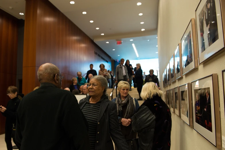 several people are standing around an art gallery