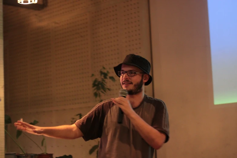 a man talking in front of a projector screen