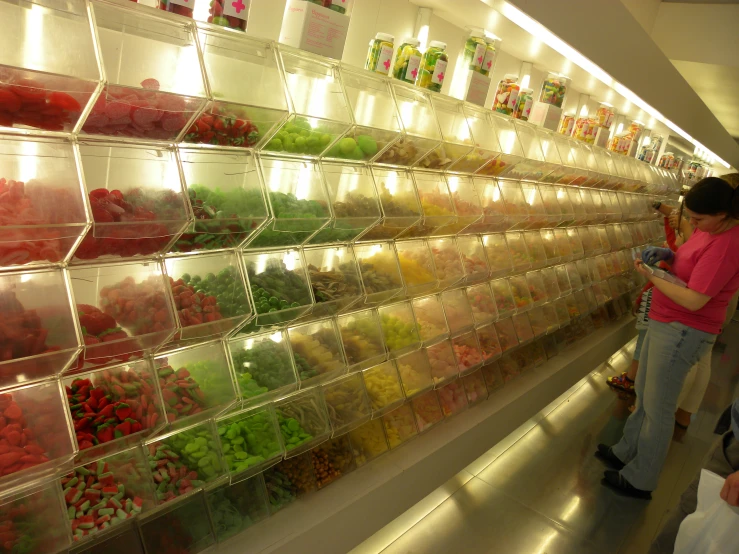 two people stand in a candy store that sells a wide variety of candies